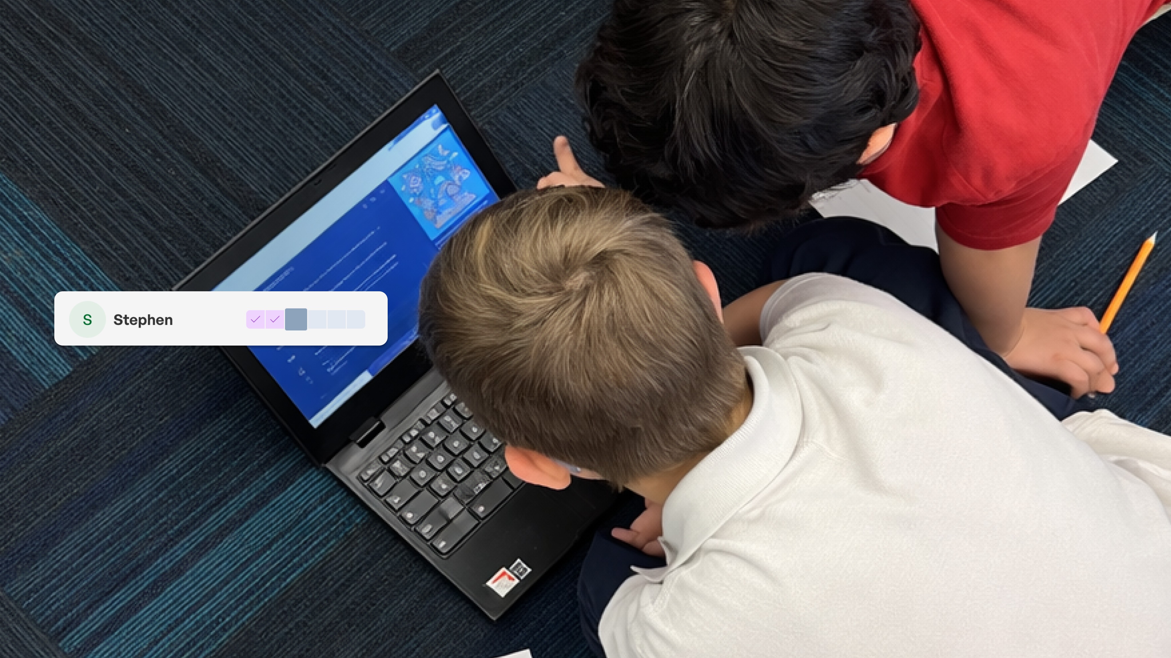 Two children work together at a laptop displaying a blue interface, with a user profile for Stephen visible in the top left…